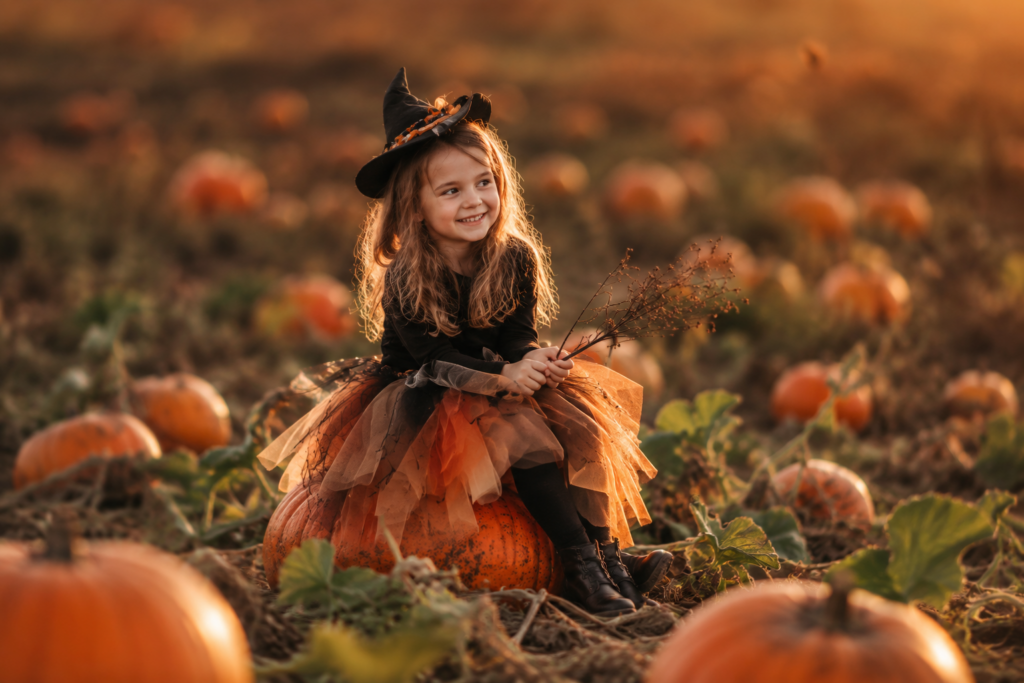 Mädchen im Hexenkostüm bei einem herbstlichen Shooting im Kürbisfeld